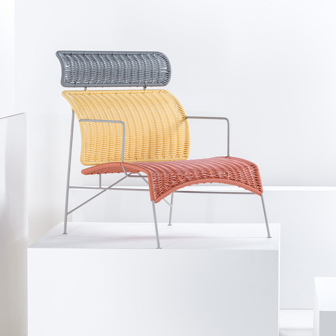 Colorful modern chair featuring a gray backrest, yellow seat, and orange cushion with wavy patterns. Stylish and vibrant design.
