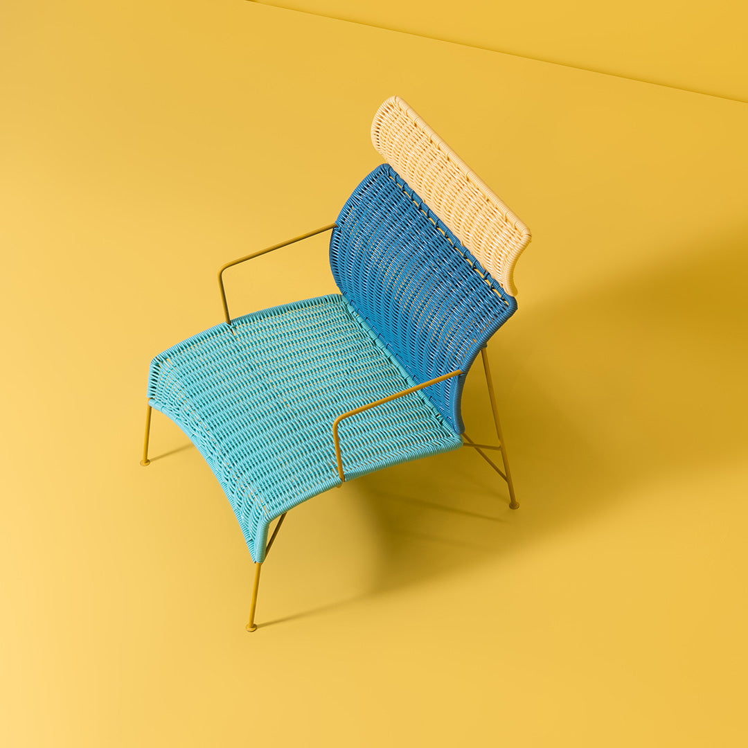 Blue and cream striped chair on a yellow background, featuring a modern, minimalist design.