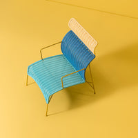 Blue and cream striped chair on a yellow background, featuring a modern, minimalist design.