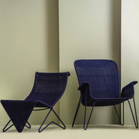 Navy blue patio chairs with sleek lines and textured patterns against a soft green background.