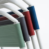 Colorful stacked chairs featuring green, gray, red, and blue ribbed patterns with white accents.