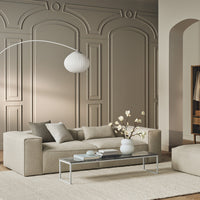 Beige and gray sofa with minimalist design, neutral color palette, and subtle textures against a light-colored wall.