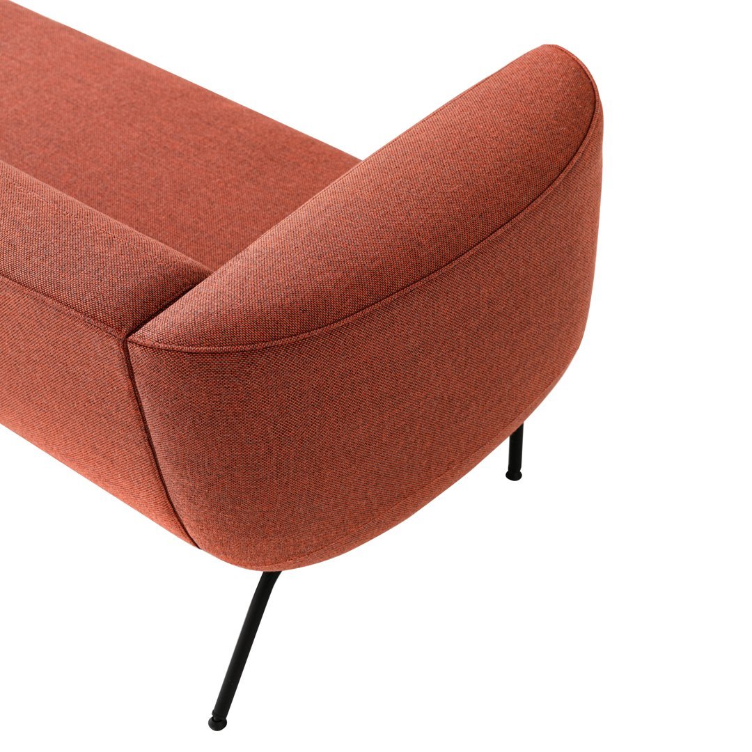 Rust-colored modern sofa with smooth, rounded edges and sleek black legs. Ideal for contemporary interiors.