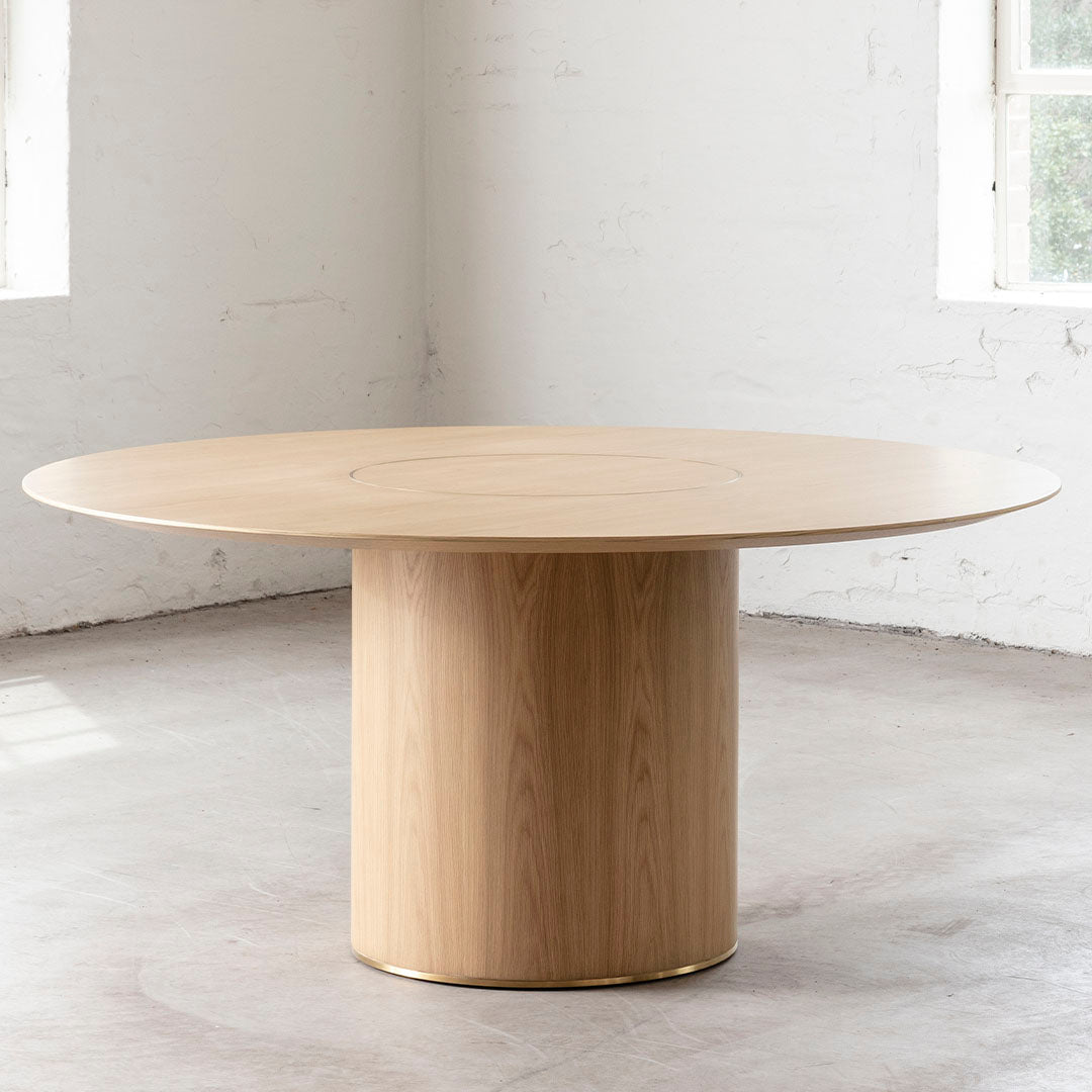 Round wooden table with a light oak finish and smooth surface, featuring a minimalist design. Ideal for modern decor.