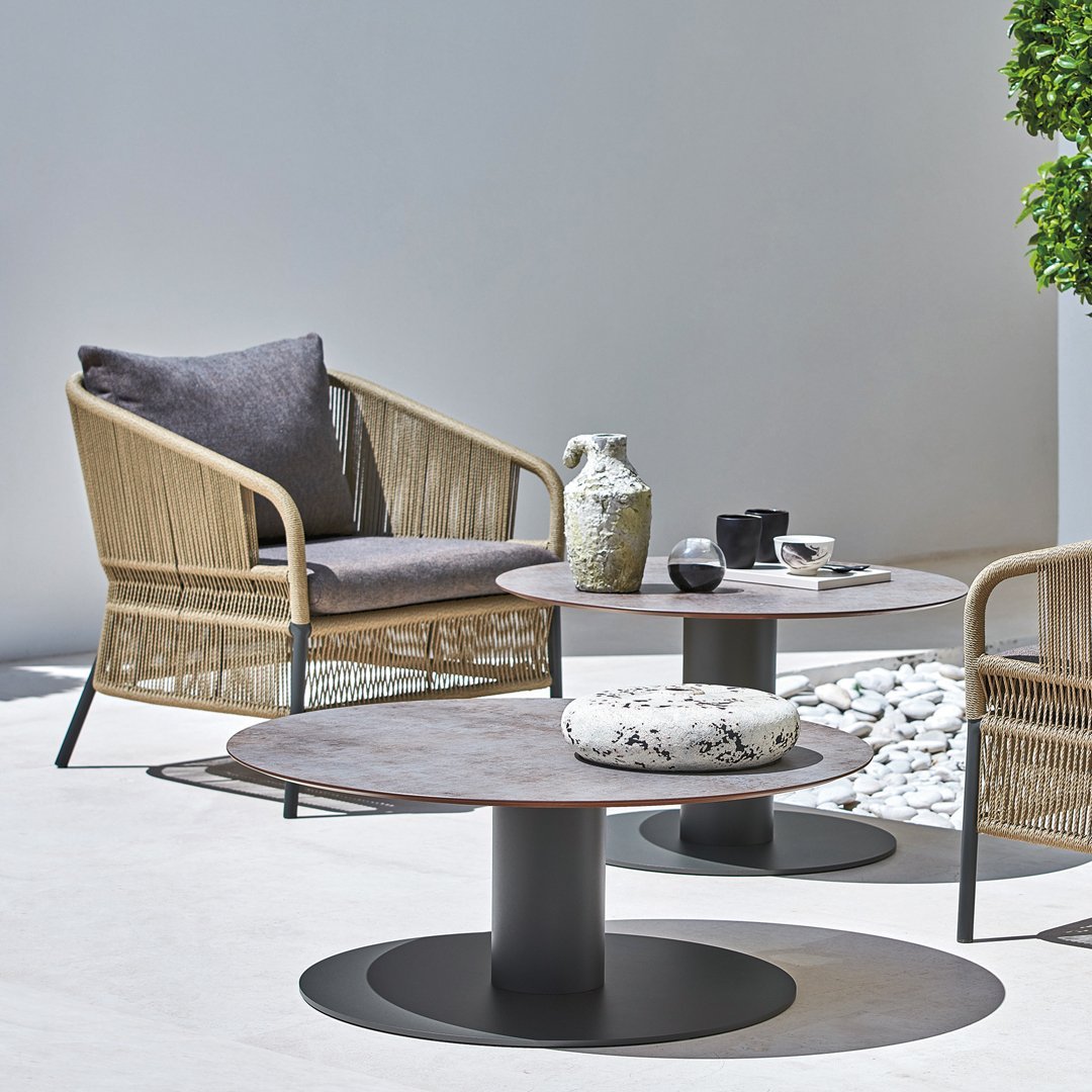 Modern outdoor seating set featuring neutral beige and gray tones with a sleek black base and natural textures.