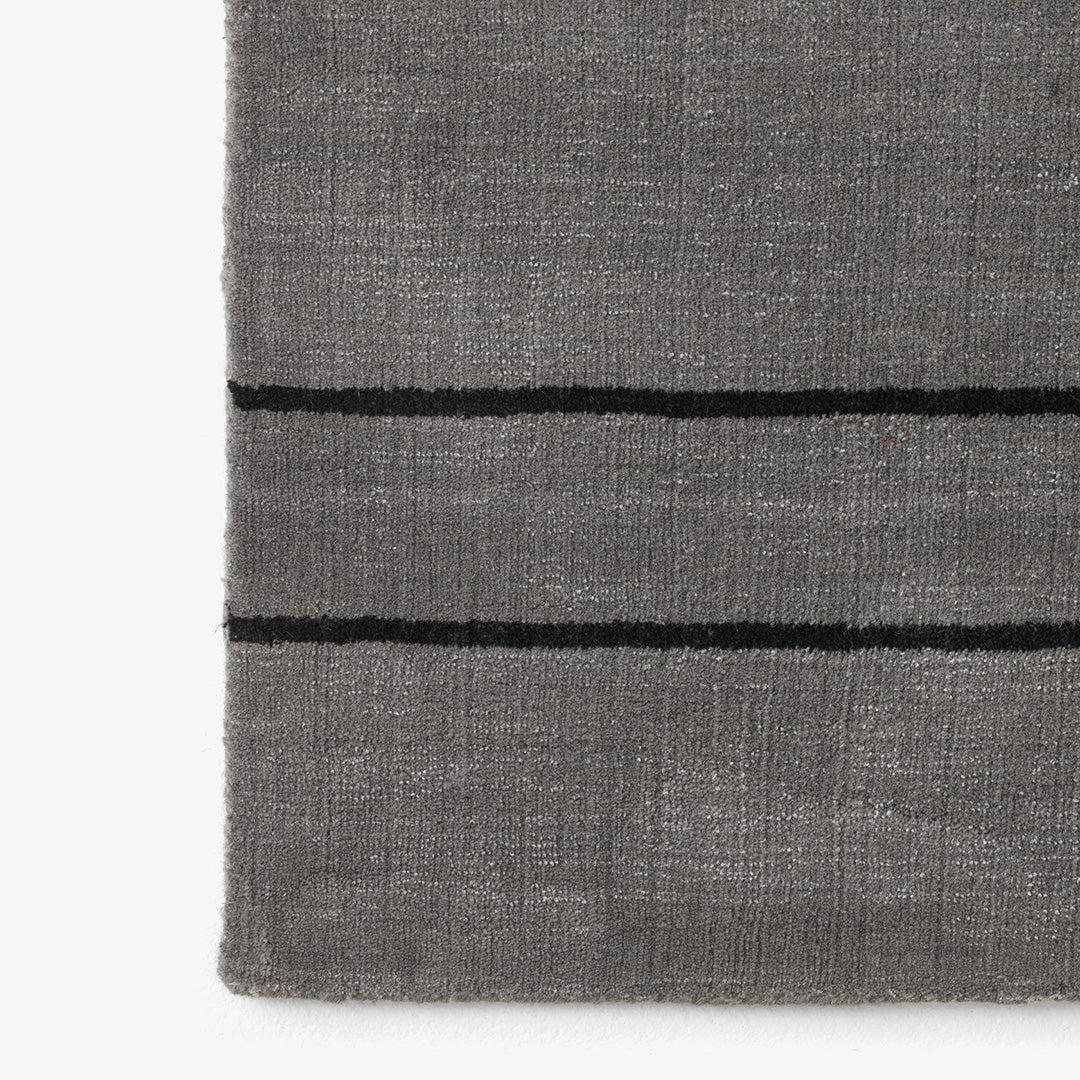 Gray textured rug with black horizontal stripes, adding a modern touch to any space.