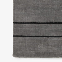 Gray textured rug with black horizontal stripes, adding a modern touch to any space.