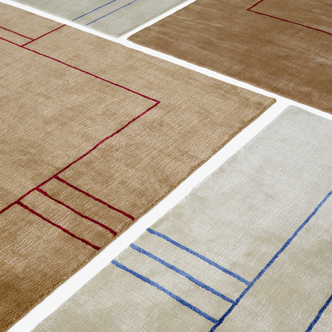 Abstract beige and tan rugs featuring red and blue geometric patterns. Perfect for modern decor.