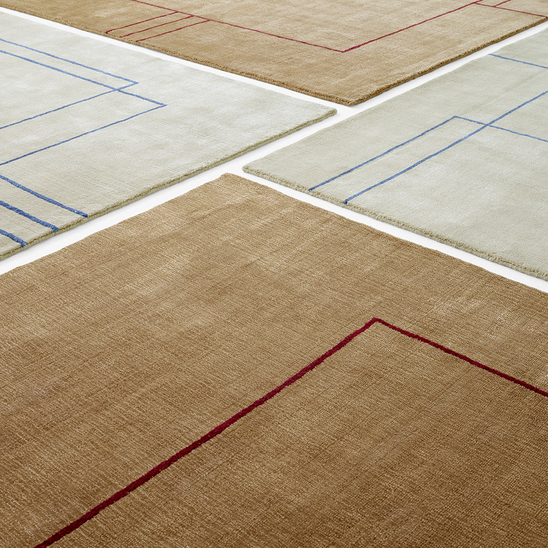 Geometric area rugs featuring beige, cream, and brown colors with blue and red linear patterns.