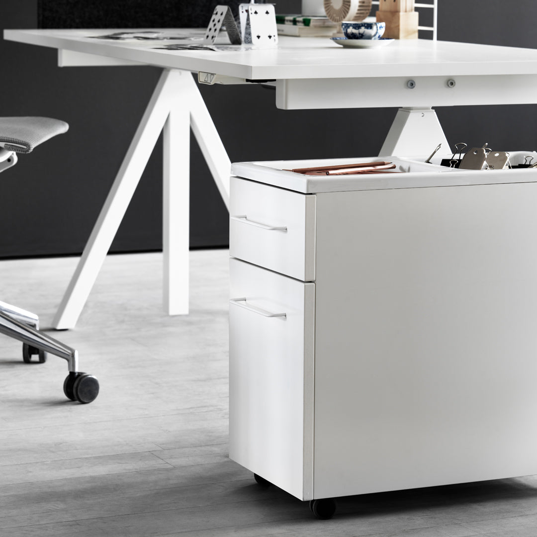 White mobile file cabinet with simple lines, complementing a sleek, modern workspace design against a gray floor.