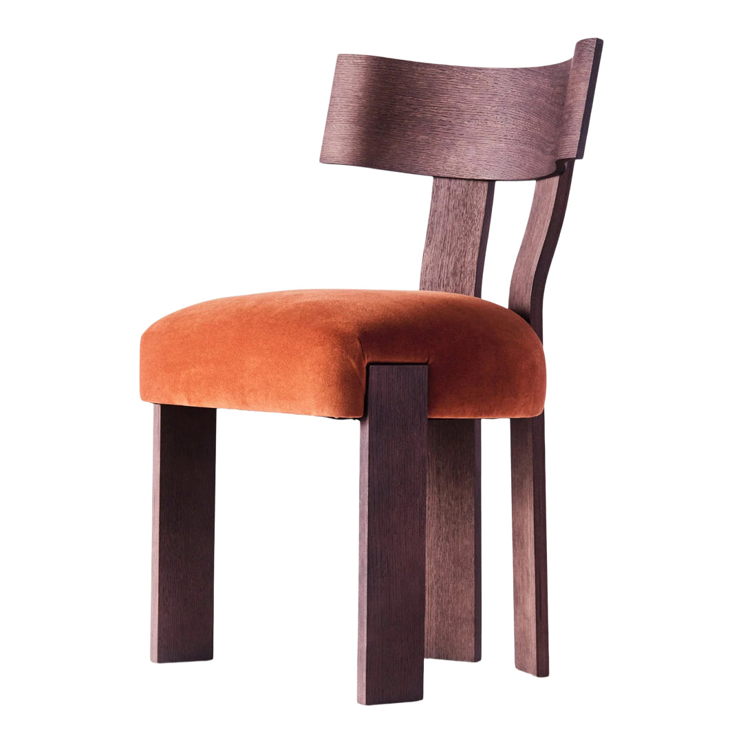 Modern chair with a dark wood frame and a rich orange velvet cushion, showcasing smooth textures and warm tones.