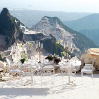 Elegant transparent dining set against a stunning mountain backdrop, featuring clear acrylic and subtle floral accents.