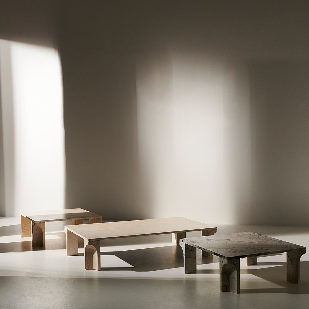 Wooden coffee tables in natural tones with minimalist design, featuring smooth surfaces and clean lines against soft shadows.
