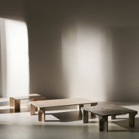 Wooden coffee tables in natural tones with minimalist design, featuring smooth surfaces and clean lines against soft shadows.