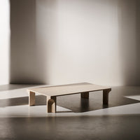 Light wood coffee table with clean lines and smooth surfaces, featuring subtle shadow play on a neutral background.