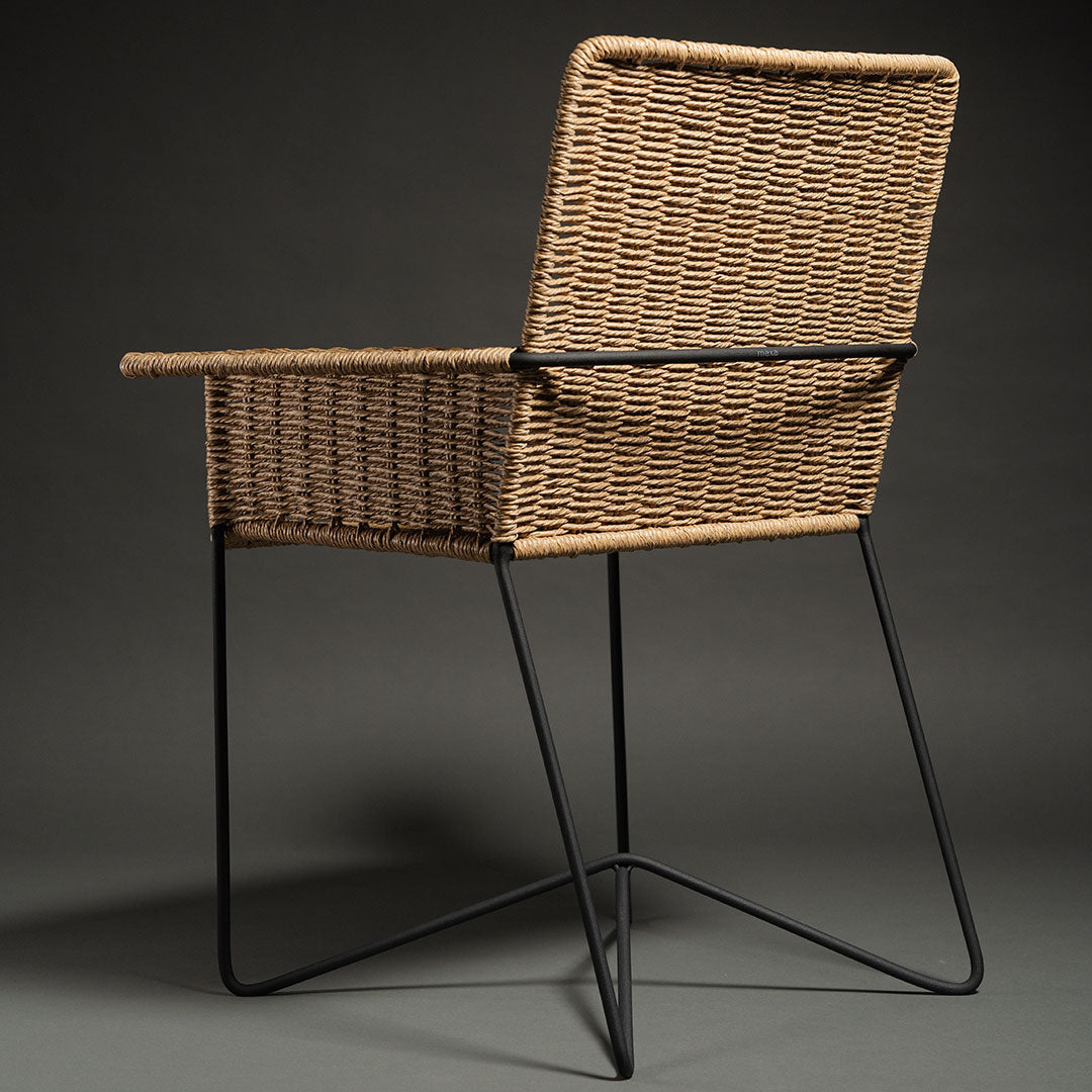 Rattan chair with a natural woven pattern and a sleek black metal frame, perfect for modern decor.