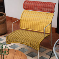 Colorful wicker chair featuring yellow and red patterns, complemented by a sleek metal frame. Perfect for modern decor.