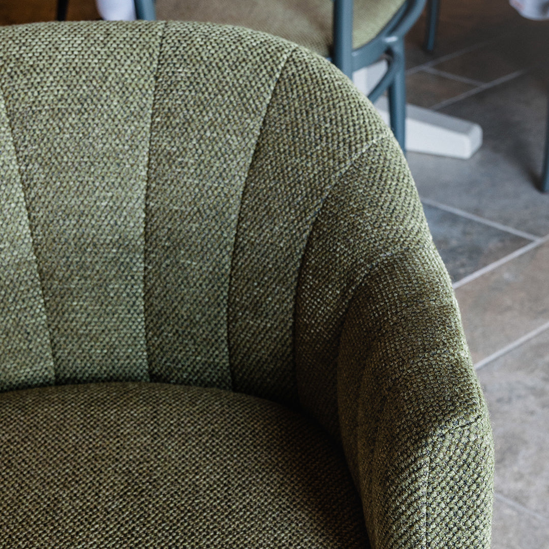 Textured green fabric chair with striped pattern, showcasing a mix of light and dark green tones.
