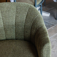 Textured green fabric chair with striped pattern, showcasing a mix of light and dark green tones.