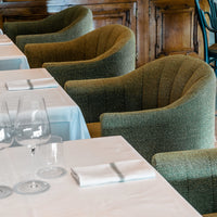 Green patterned chairs set against a white tablecloth, creating a stylish and inviting dining atmosphere.