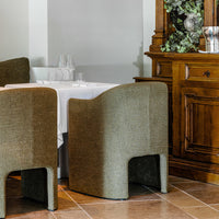 Olive green textured chairs with a minimalist design beside a wooden sideboard in a cozy dining setup.