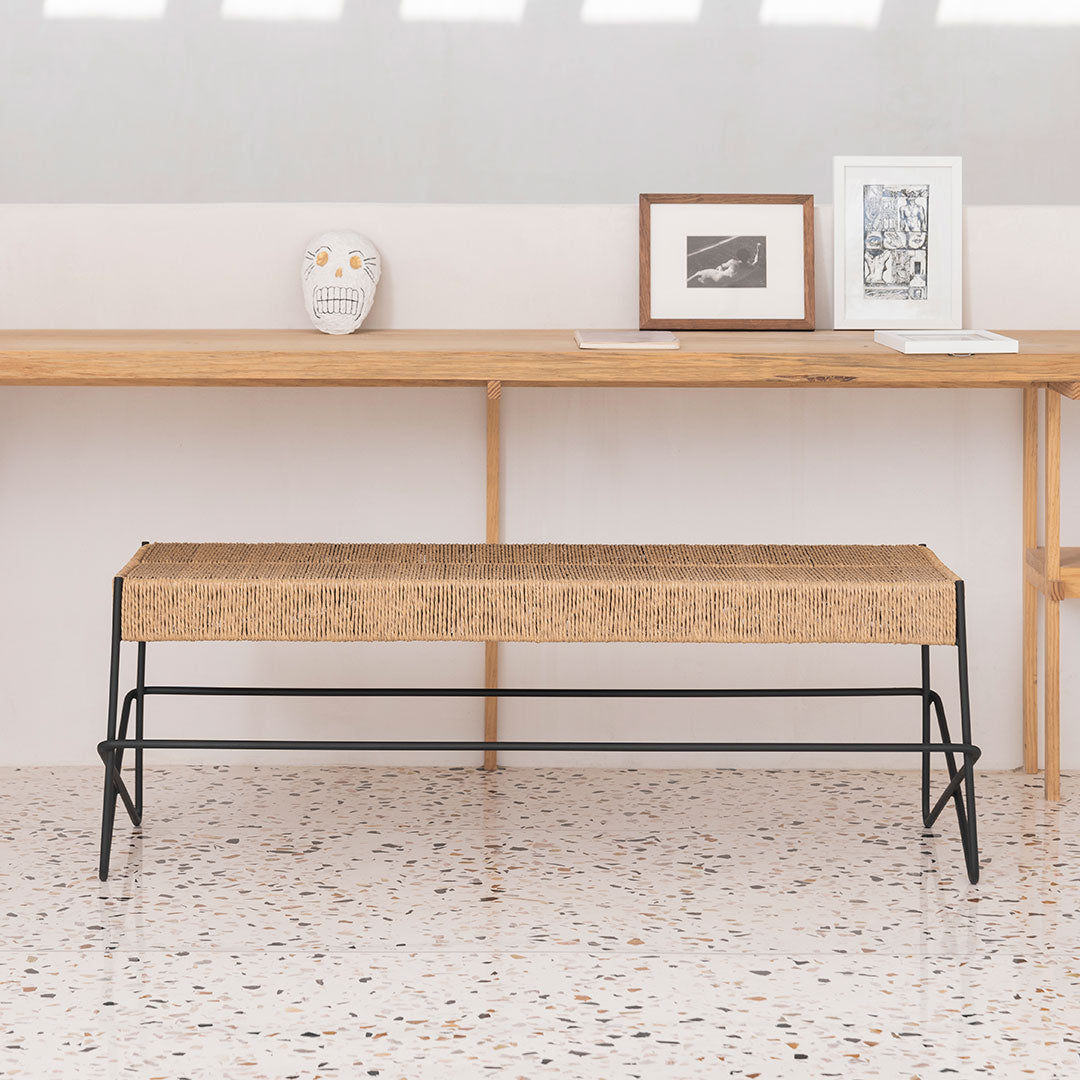 Natural wood bench with a textured beige top and sleek black metal legs, perfect for modern decor.