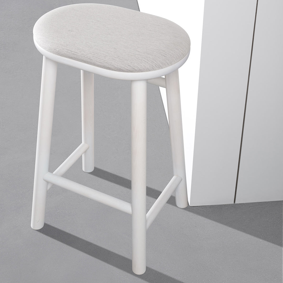 Light gray upholstered stool with a sleek white frame, set on a gray surface. Modern and minimalist design.
