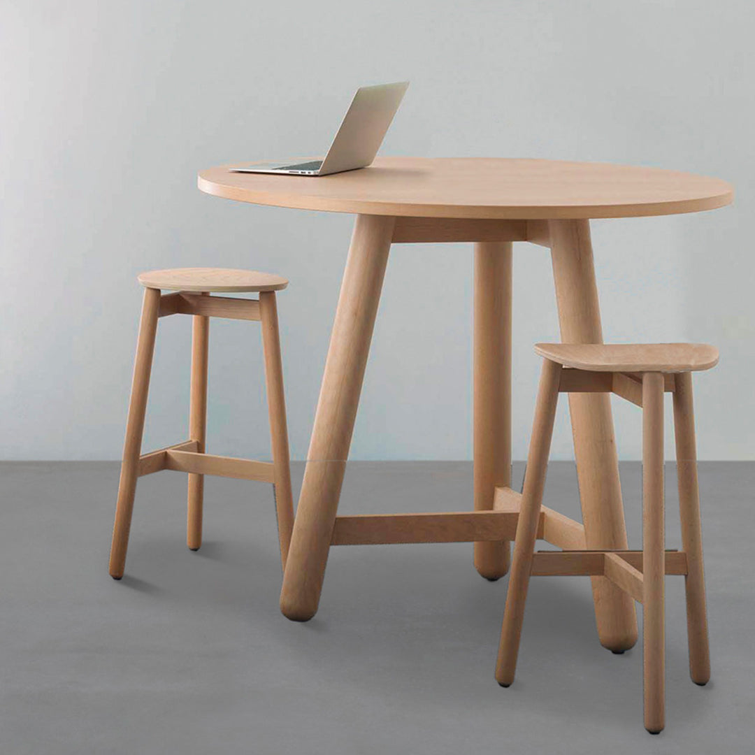 Light wood dining table with matching stools, featuring a smooth, natural finish on a neutral gray floor.