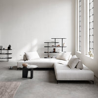 Modern cream sectional sofa with geometric patterns and neutral accents in a minimalist setting.