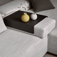 Gray textured sofa with a sleek black tray, featuring yellow and white vases, adding modern color contrast.