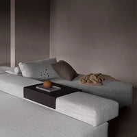 Gray textured sofa with soft beige cushions and a deep brown table, creating a modern, minimalist aesthetic.
