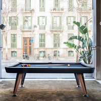 Stylish black pool table with rich wooden legs, featuring vibrant colored balls and soft beige carpet.