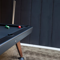 Black pool table with three colorful balls: green, red; modern design against a textured dark backdrop.