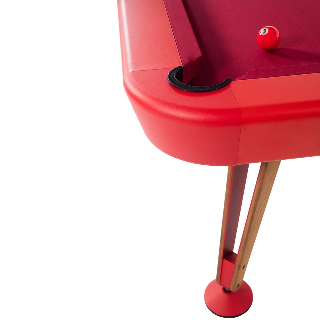 Red pool table with burgundy felt and black accents, featuring wooden legs for a stylish and modern look.