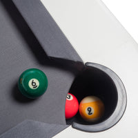 Green, red, yellow, and orange billiard balls on a gray table with a black hole. Modern design and vibrant colors.