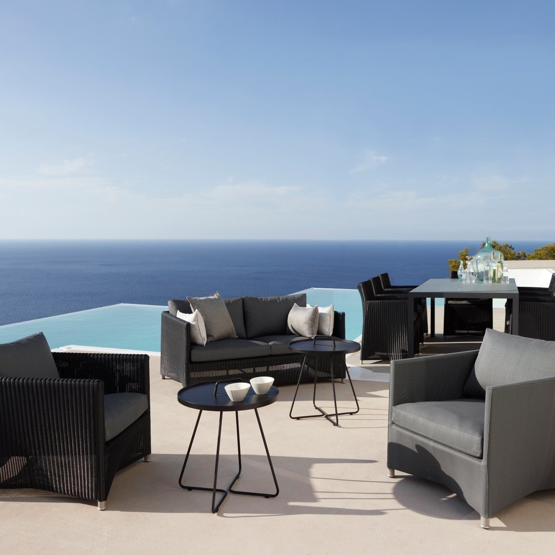 Modern outdoor furniture set in sleek black with gray cushions, featuring a minimalistic pattern for a chic look.