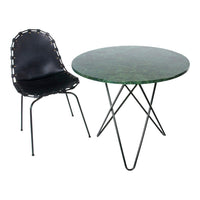 Modern round green marble table paired with a stylish black chair featuring a unique stitched edge design.