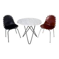Black and brown accent chairs with stitched edges beside a round marble-top table on black metal legs.