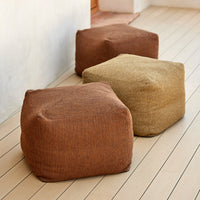 Textured poufs in warm brown and beige hues, showcasing a natural woven pattern. Ideal for cozy, stylish decor.