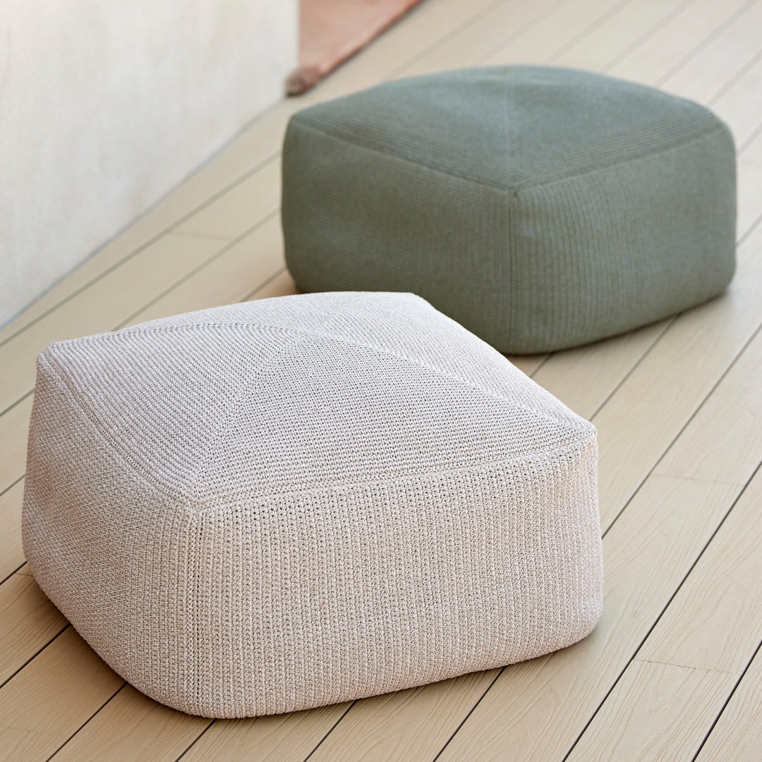 "Two textured poufs in light beige and muted green, showcasing modern geometric patterns."