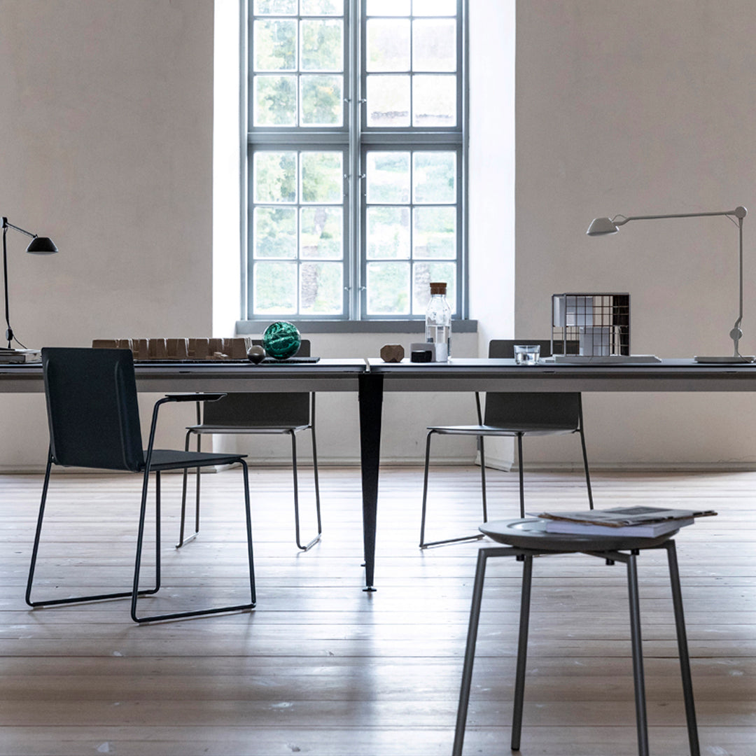 Modern workspace featuring a smooth, light wood floor, sleek gray chairs, and minimalist decor in neutral tones.
