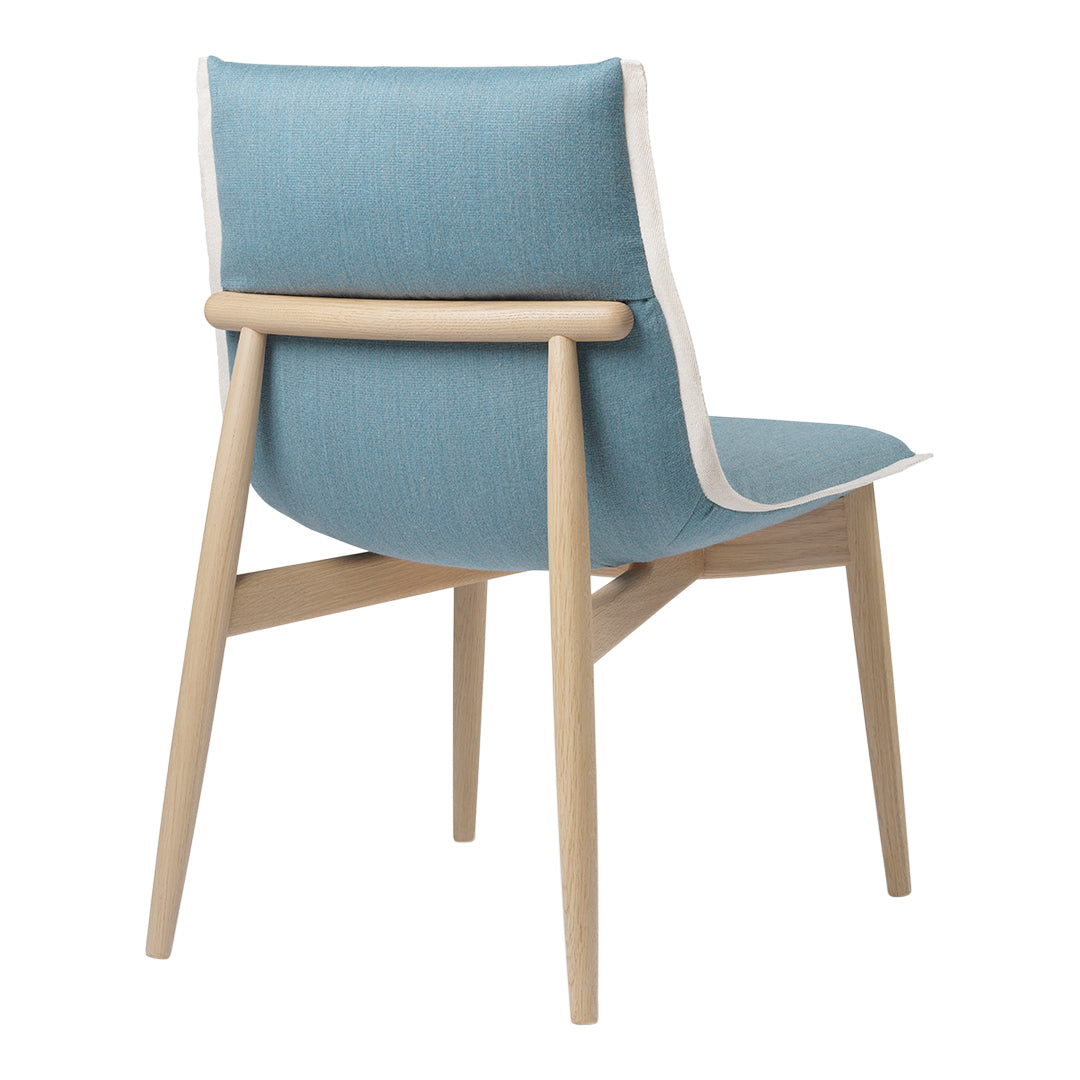 Light blue fabric chair with a natural wood frame and white trim, showcasing a modern, minimalist design.