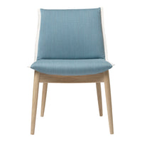Light blue upholstered chair with a textured fabric and natural wooden legs. Modern design with a minimalist aesthetic.
