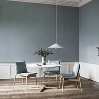 Light blue walls, gray patterned floor, and soft blue chairs create a serene dining space with a modern aesthetic.