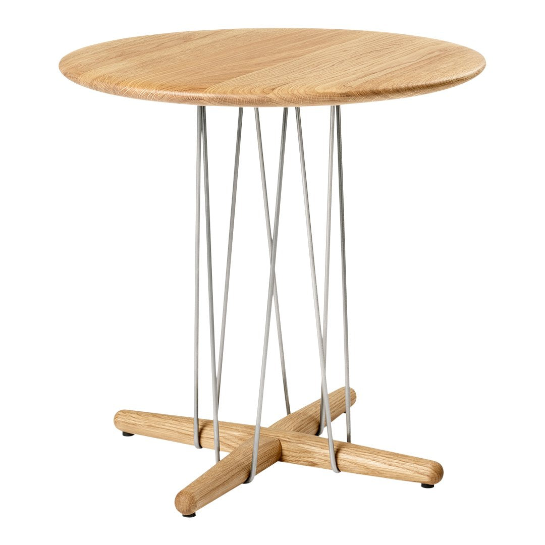Light oak round table with a natural wood finish and modern silver metal legs, featuring a minimalist design.