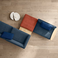 "Modern sectional sofa in navy blue, terracotta, and deep blue upholstery with minimalist wood accents."