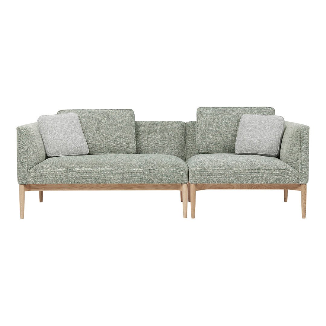 Light green fabric sofa with textured pattern and two gray cushions, complemented by natural wooden legs.