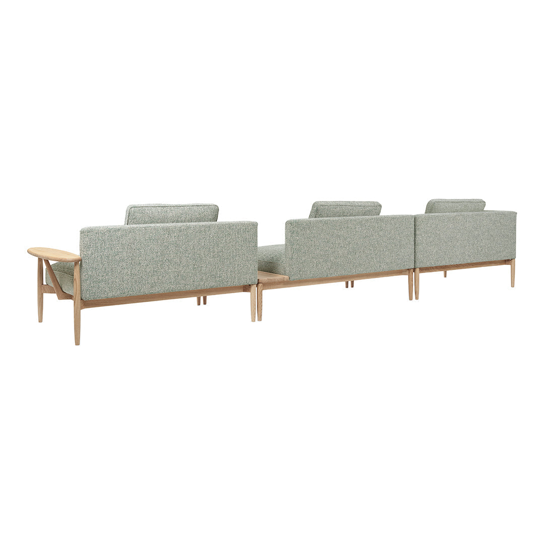 Light gray upholstered sofa with subtle textured pattern on a natural wood frame. Modern and minimalist design.