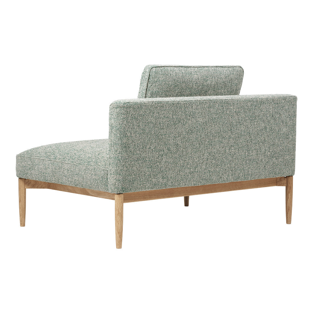 Mint green textured upholstery with subtle patterns on a modern, minimalist chaise lounge. Natural wood legs.