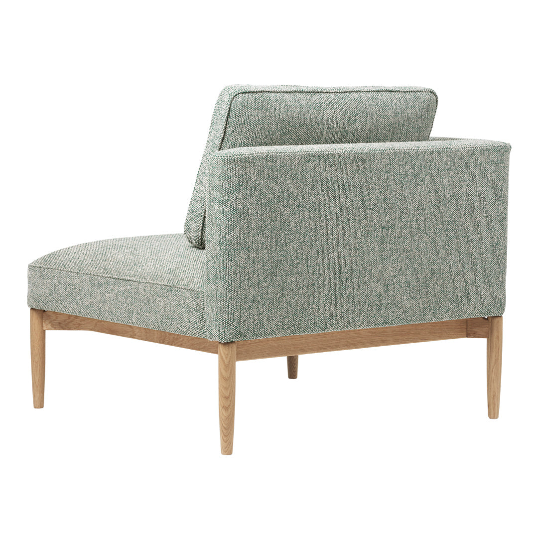 Light green textured fabric armchair with wood legs, featuring a subtle pattern for a modern, elegant look.